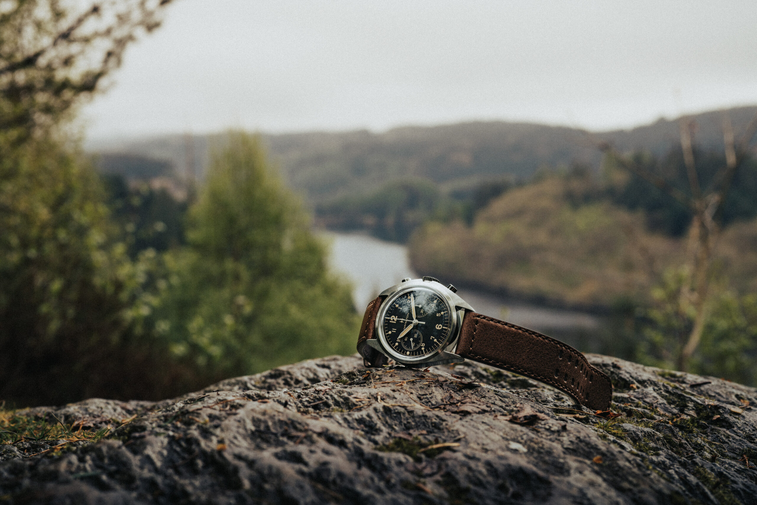 Hamilton khaki aviation pilot pioneer mechanical lying on rocks with a loch in the background