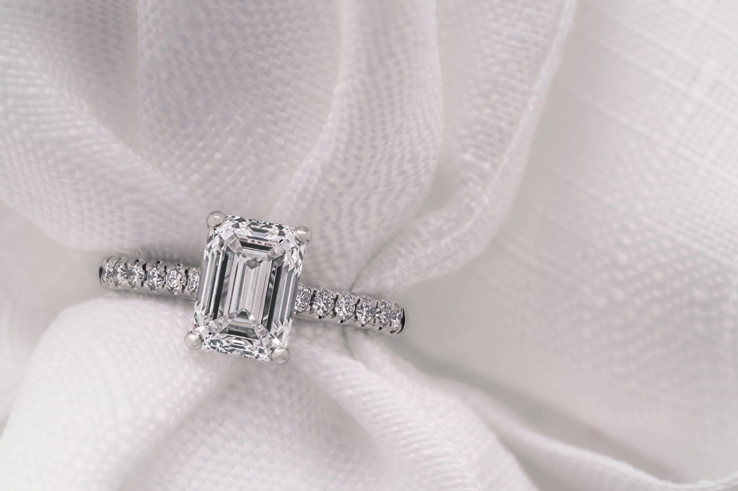 Emerald cut diamond engagement ring with diamond shoulders